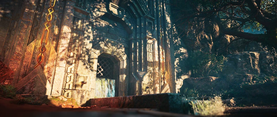 Stone gateway set into a rock face in low sunlight, with trees overhanging