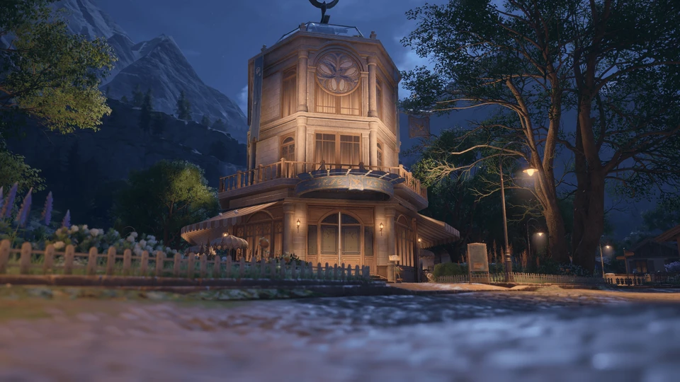 Octagonal clock tower building beside a lamp-lit path at night, with mountains behind