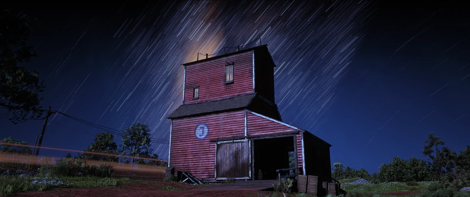 Red barn under a dark blue night sky with streaking light
